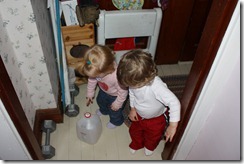 An empty apple cider jug is very intriguing to the twins. Who needs toys?